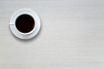 Fototapeta na wymiar White coffee cup on wooden table top view
