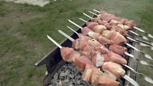 Barbeque skewers with meat cooking on hot coal ember brazier Outdoors picnic concept. 4K UHD video footage.