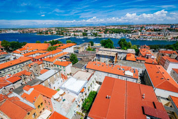 Naklejka premium Sunny summer day above old town of Zadar. Panoramic view from the height at center of Zadar and red rooftops.
