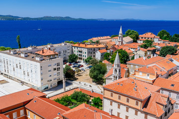 Fototapeta na wymiar Sunny summer day above old town of Zadar. Panoramic view from the height at center of Zadar and red rooftops.