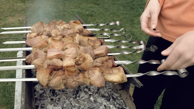 Barbeque skewers with meat cooking on hot coal ember brazier Outdoors picnic concept. 4K UHD video footage.