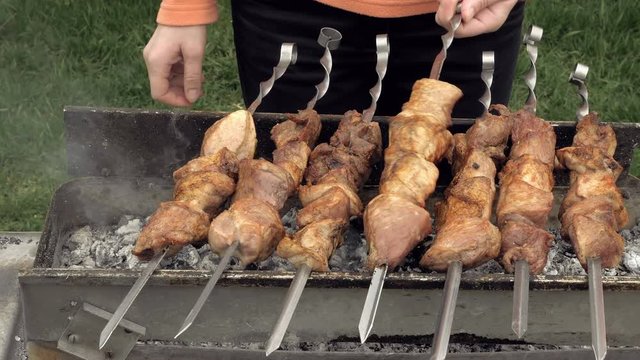 Barbeque skewers with meat cooking on hot coal ember brazier Outdoors picnic concept. 4K UHD video footage.