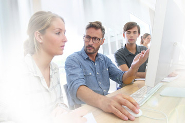 School instructor helping students with work project