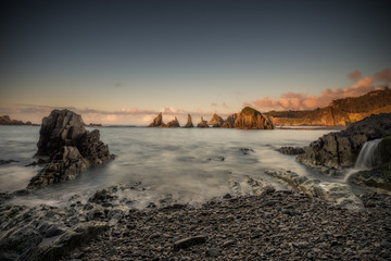 Cliffs and ocean at sunset. Cloudy sky, Cantabria, Spain