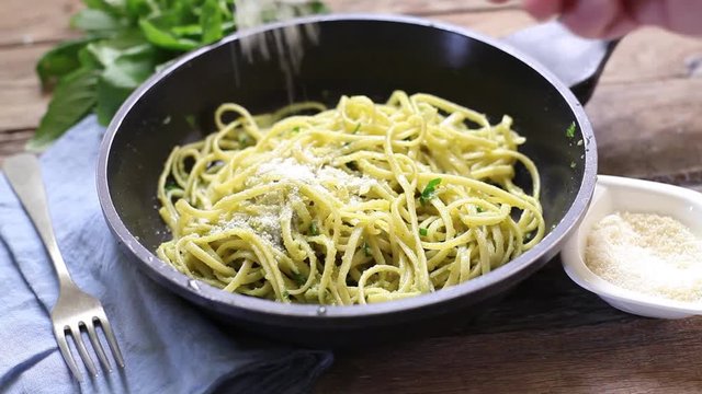 preparing pasta with pesto sauce
