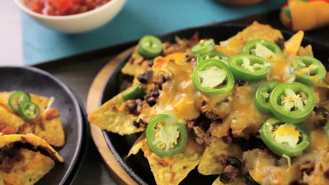 Classic nachos with ground beef and fresh jalapeno chili peppers