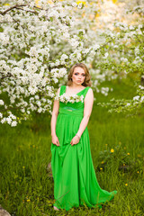 Beautiful happy young woman in spring blossoming garden