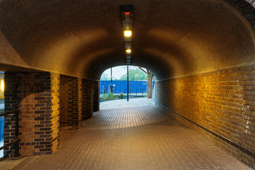 London urban underground brick tunnel with lights next to Albion Channel