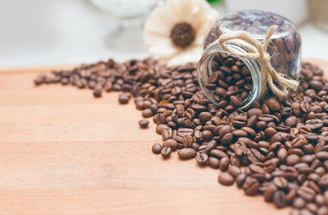 Кофейные зерна россыпью и в банке  на деревянном фоне 