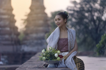 Woman wearing typical thai dress with thai style temple backgrou