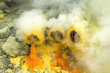 Molten sulfur dripping from pipes at Kawah Ijen volcano, East Java, Indonesia. - obrazy, fototapety, plakaty