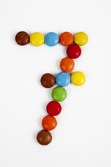 Il numero sette formato da coloratissimi confetti di cioccolato.