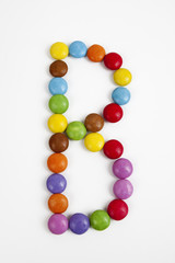 La lettera B formata da coloratissimi confetti di cioccolato.