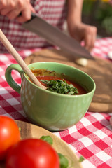 Frau schneidet Zutaten für meditterane Küche