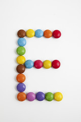 La lettera E formata da coloratissimi confetti di cioccolato.