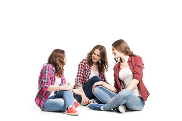 three young women sittingover white background 
