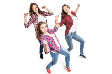 three young women dancing over white background 