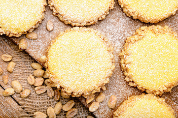 Butter cookies (alfajores) with caramel and peanut on wooden background.