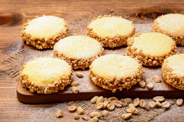 Fototapeta na wymiar Butter cookies (alfajores) with caramel and peanut on wooden background.
