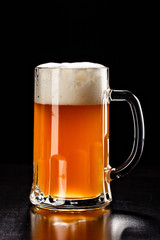 Beer Glass on black. Bar drink. Beer bubbles closeup. DRAFT LIGHT. Overflow beer glass. Beer beverage. Glass of alcohol. Closeup draft beer glass. Cold Beer. Pint of beer. Good for brewery commercial