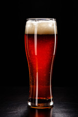 Beer Glass with DROPS on black. FRESH! MUCH FOAM! Beer bubbles closeup. DRAFT. Overflow beer glass. Beer beverage. Glass of alcohol. Closeup Cold Beer. Pint of beer. Good for brewery commercial