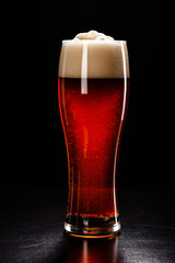 Beer Glass with DROPS on black. FRESH! MUCH FOAM! Beer bubbles closeup. DRAFT. Overflow beer glass. Beer beverage. Glass of alcohol. Closeup Cold Beer. Pint of beer. Good for brewery commercial