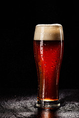 Beer Glass with DROPS on black. FRESH! MUCH FOAM! Beer bubbles closeup. DRAFT. Overflow beer glass. Beer beverage. Glass of alcohol. Closeup Cold Beer. Pint of beer. Good for brewery commercial