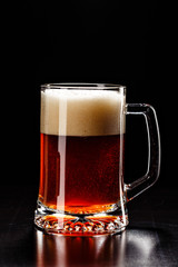 Beer Glass with DROPS on black. FRESH! MUCH FOAM! Beer bubbles closeup. DRAFT. Overflow beer glass. Beer beverage. Glass of alcohol. Closeup Cold Beer. Pint of beer. Good for brewery commercial