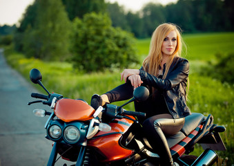 Fototapeta na wymiar Outdoor fashion portrait of young sexy tan blonde woman posing red scooter bike at sunshine.