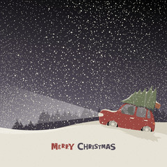 Greeting card with a man carries home a Christmas tree on car roof in a snowy night