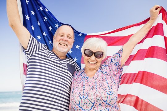 Senior couple holding american flag together