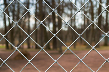 Fototapeta premium Steel Grating grid on blur park background. 