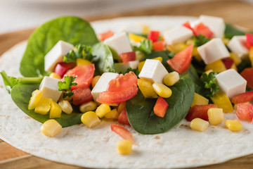vegan tofu wraps with pepper, corn, tomatoes and spinach