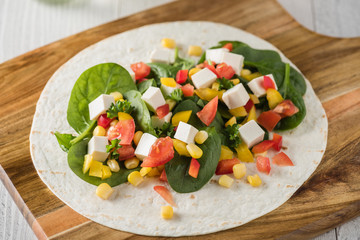 vegan tofu wraps with pepper, corn, tomatoes and spinach
