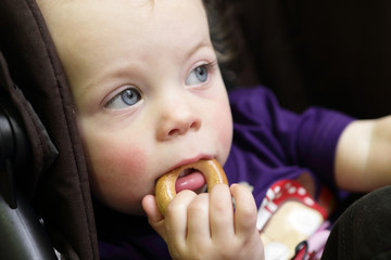 Pensive child eating bagel