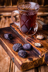 Dates with tea on vintage wooden background. Selective focus. Toned image