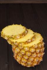 Sliced fresh, ripe pineapple on a wooden table. Preparation of dietary supplements.

