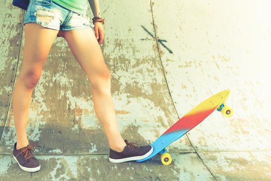 Close-up skateboarder girl with skateboard outdoor at skatepark