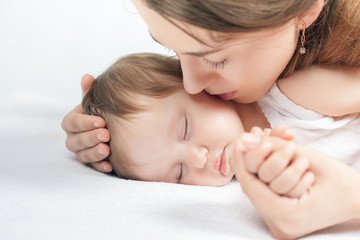 Obraz na płótnie Canvas Mother kissing a baby. Care concept
