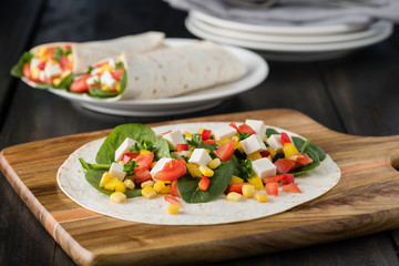vegan tofu wraps with pepper, corn, tomatoes and spinach