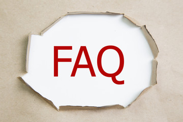 The acronym FAQ - Frequently Asked Questions appearing behind torn paper. 
