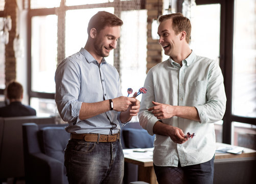 Cheerful Friends Holding Darts  