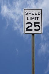 25 MPH SPEED LIMIT SIGH WITH BRIGHT BLUE SKY BACKGROUND
