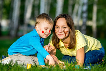 Mother and son dirty and paint outdoors