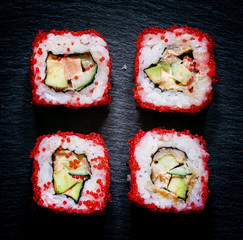 Philadelphia Roll with caviar, top view, a dark stone background