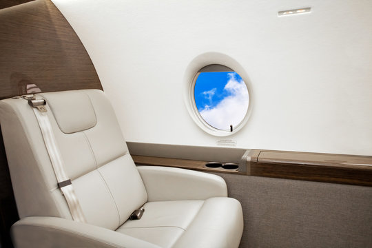 Aircraft porthole with clouds view, flight by business class