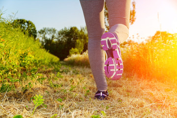 Woman running at sunset in a field