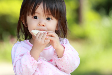 Fototapeta premium おやつを食べる幼児(1歳児)