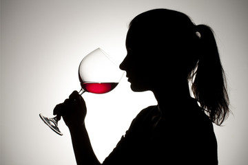 silhouette of a girl drinking wine.