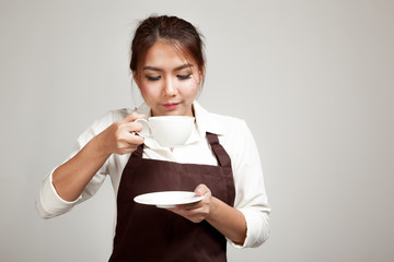 Waitress or barista  in apron drinking coffee